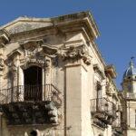 Uno scorcio dell'edificio con un campanile sullo sfondo